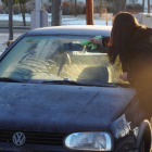 Una dona retira el gel del seu vehicle