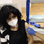 La farmacéutica Sílvia Pallàs recibe la vacuna y a la derecha, colas ante el pabellón Onze de Setembre.
