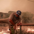 Un home fuig de les flames d’un incendi a la localitat grega de Pefki, ahir.