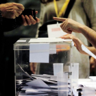 Una persona s'acredita per votar en un col·legi electoral de Ciutat Vella de Barcelona