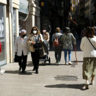 Gent passejant per l'Eix Comercial de Lleida amb mascareta.