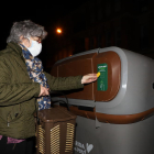 Una veïna de Pardinyes tira l’orgànica en un dels contenidors amb la seua targeta individual.