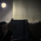 Un jove llegeix sota un llum de baixa potència en plena onada de fred i alts preus de la llum.