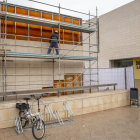 Un operario trabajando ayer en una de las fachadas afectadas, en la que ya se han retirado las placas de piedra de las filas superiores.