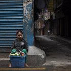 Una niña vende “snacks” en una calle en Katmandú.