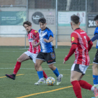 Un jugador del Solsona conduce el balón con la oposición de un rival.