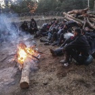 Un grup de migrants espera al voltant d’una foguera una oportunitat per creuar Polònia.