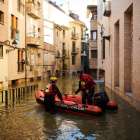 Dos bombers naveguen per un dels carrers inundats de Tudela.