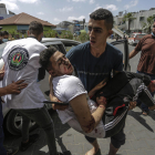 Un jove palestí trasllada un ferit pels bombardejos israelians a la ciutat de Gaza.