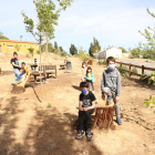 Varios niños de Sucs prueban los nuevos bancos hechos con los tocones de pinos en el parque del Vilot.