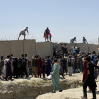 Desenes d’afganesos intenten entrar a les pistes de l’aeroport de Kabul saltant els filats.