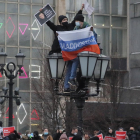 Manifestantes encaramados a una farola en Moscú, ayer.