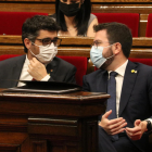 El presidente del Govern, Pere Aragonès, conversa con el vicepresidente, Jordi Puigneró, durante el pleno en el Parlament.