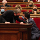 El conseller de Economía, Jaume Giró, hablando con el presidente del Govern, Pere Aragonès, durante el pleno del Parlament.