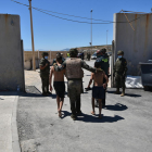 Un militar de l'exèrcit espanyol i un agent de la Guàrdia Civil ajuden dos menors migrants procedents del Marroc a la seua arribada a Ceuta.