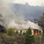 Una casa en Los Llanos siendo devorada por las colas de lava que bajan desde Cumbre Vieja, que ya han arrasado más de un centenar.