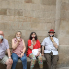Vecinos de Lleida haciendo el ademán de quitarse la mascarilla en el banco del “si no fos” de la Paeria.