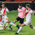 Leo Messi, envoltat per tres defensors del Rayo Vallecano, va tornar ahir després de complir la sanció per l’expulsió a la Supercopa.