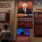 Un jove contempla un quadre de Xi Jinping en un museu.