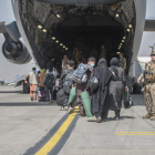 Ciudadanos afganos a punto de embarcar en una aeronave estadounidense que les aleje de la barbarie talibán.