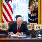 El presidente de los Estados Unidos, Joe Biden, firmando una orden legislativa en el despacho oval.