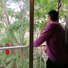 Ch. T., mirando por el balcón de su casa, donde lleva 5 años, gracias al programa Housing First.