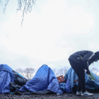 Un migrante busca entre las tiendas de un campamento instalado en Calais. 