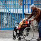 Un hombre pasea a su perro junto a una residencia de ancianos.