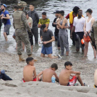 Menores sentados en la playa tras arribar a Ceuta la semana pasada.