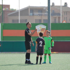 Xavier Estrada llança la moneda per al sorteig de camp ahir al Bordeta-Alpicat de benjamins davant del seu fill Marc, de cara.