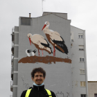 El artista Oriol Arumí posa ante la fachada que acoge el mural.