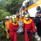 Bombers taiwanesos retiren un dels cossos de les víctimes mortals en el descarrilament.