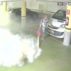 Imatge de la càmera de seguretat d'un dels aparcaments comunitaris on es pot veure el detingut buidant un extintor.