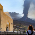 Diverses persones observen com descendeix una de les noves colades generada per l’ensorrament del volcà de La Palma.
