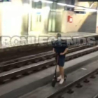 Graven un noi anant en patinet elèctric per les vies del tren a Barcelona