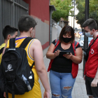 Dos voluntaris de Creu Roja parlant amb dos joves a Lleida.