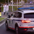 Un cotxe de l’Ertzaintza i diversos alumnes, davant la facultat de Leioa on va tenir lloc el tiroteig.