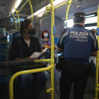 Un agent de la Policia Municipal madrilenya comprova en un autobús el compliment de les restriccions de mobilitat.