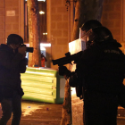 Un periodista fotografia uns agents dels Mossos d'Esquadra amb una llançadora de foam