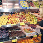 Foto d’arxiu d’una dona comprant fruita en un supermercat.