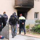 Agentes en el lugar del suceso y, de fondo, una ventana ennegrecida.