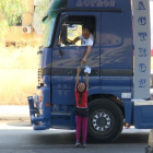 Una nena ven aigua a un camioner, a Beirut.
