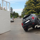 Un coche queda semivolcado en la entrada de un parking en Lleida
