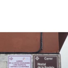 La placa que luce junto a la oficial de la calle Hostal de La Bordeta. 