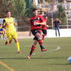 Un jugador de l’EFAC Almacelles passa la pilota davant de l’atenta mirada d’un contrari i del col·legiat.