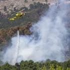 Un helicòpter descarrega aigua en el punt d’inici del foc.