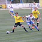 Un jugador del Mollerussa agarra de la camiseta al capitán del Lleida B, que trata de controlar el balón.