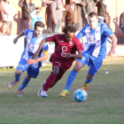 Un jugador de l’Agramunt avança amb perill davant la pressió de dos jugadors del Torregrossa.