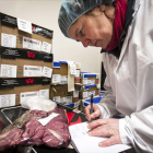 Una investigadora anotando datos sobre una partida de carne.