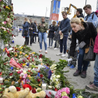 Miles de personas se acercaron ayer al lugar del atentado en Estocolmo a depositar flores y velas.
